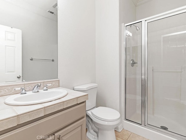 bathroom featuring tile patterned floors, toilet, a shower with shower door, and crown molding