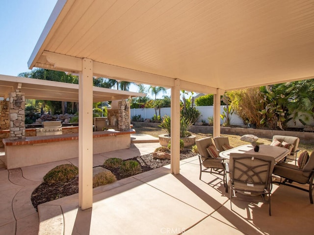 view of patio / terrace featuring an outdoor stone fireplace and grilling area