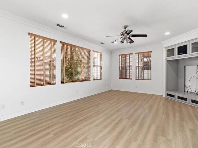 unfurnished living room featuring light hardwood / wood-style flooring, plenty of natural light, and ornamental molding