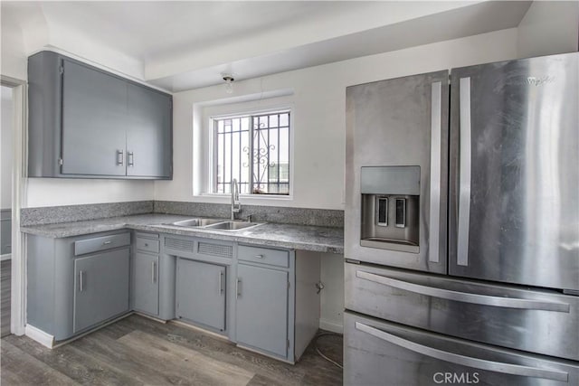 kitchen featuring dark hardwood / wood-style floors, gray cabinets, sink, and stainless steel refrigerator with ice dispenser