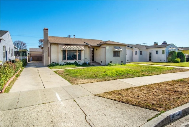 9130 S Wilton Pl, Los Angeles, CA 90047 - bungalow with stucco siding, a front yard, concrete driveway, and a chimney
