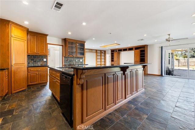 kitchen featuring ceiling fan, black dishwasher, a kitchen breakfast bar, backsplash, and a center island with sink