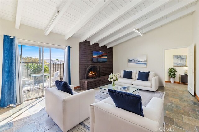 living room featuring a fireplace, lofted ceiling with beams, rail lighting, and wood ceiling