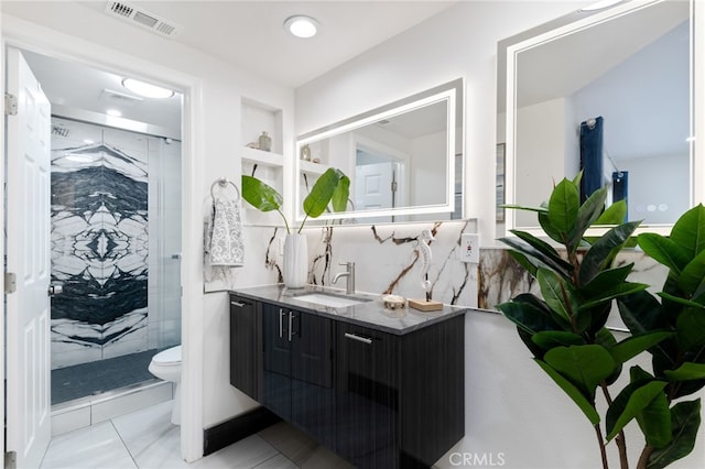 bathroom featuring vanity, tile patterned floors, toilet, tasteful backsplash, and an enclosed shower