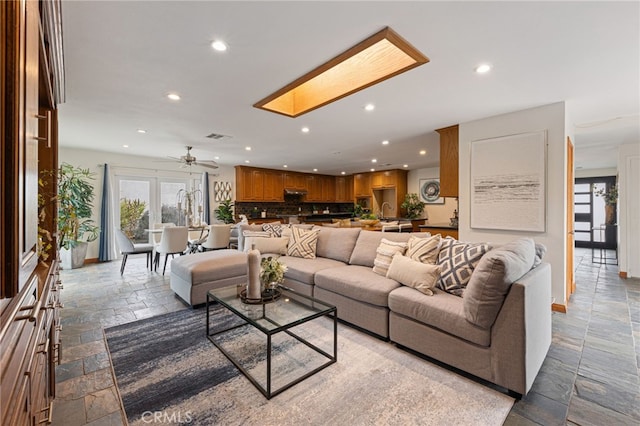 living room with a skylight and ceiling fan