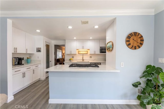 kitchen with white cabinetry, light hardwood / wood-style flooring, kitchen peninsula, and stainless steel gas cooktop