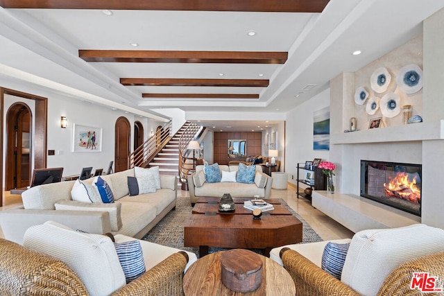 living room featuring beam ceiling, a premium fireplace, and light tile patterned floors