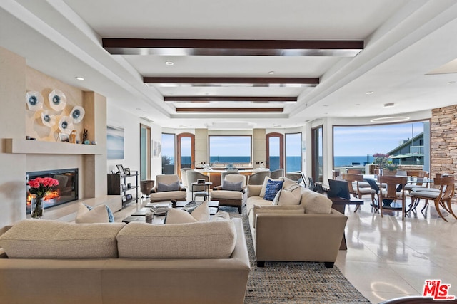 tiled living room featuring beamed ceiling and a water view