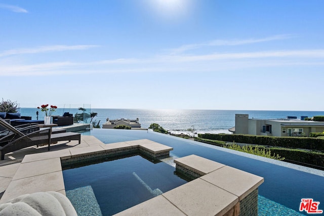 view of pool with a patio area and a water view