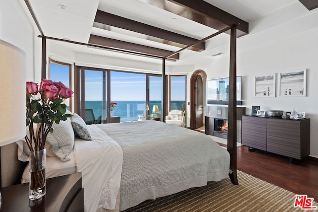 bedroom featuring beamed ceiling and dark hardwood / wood-style floors