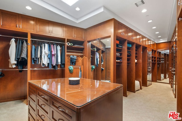 walk in closet featuring light colored carpet