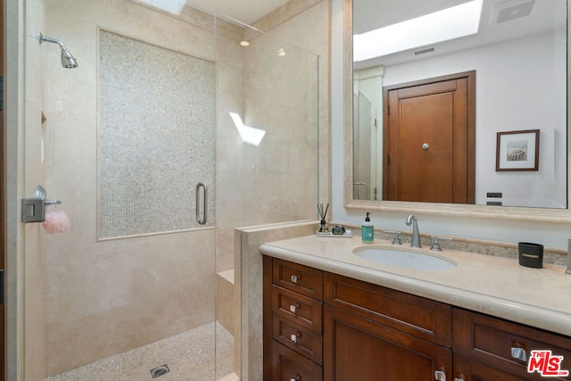 bathroom with vanity and a shower with shower door