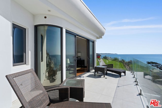 view of patio featuring a water view and a balcony