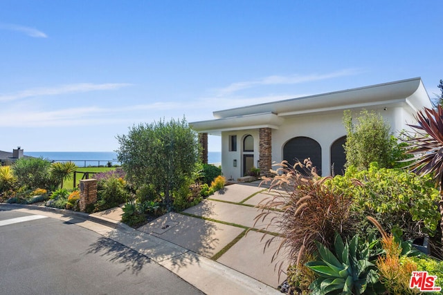 view of front facade featuring a water view and a garage