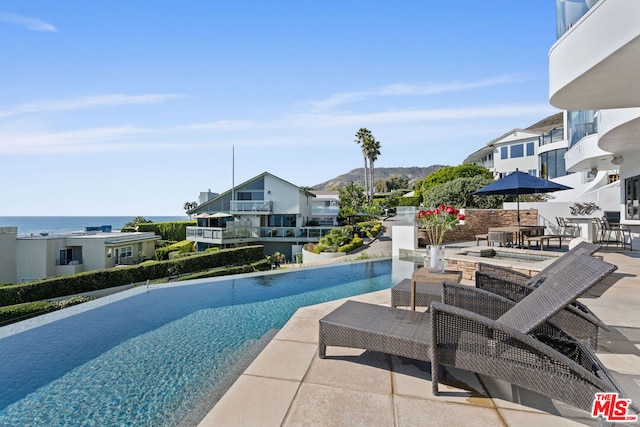 view of pool with a patio area and a water view