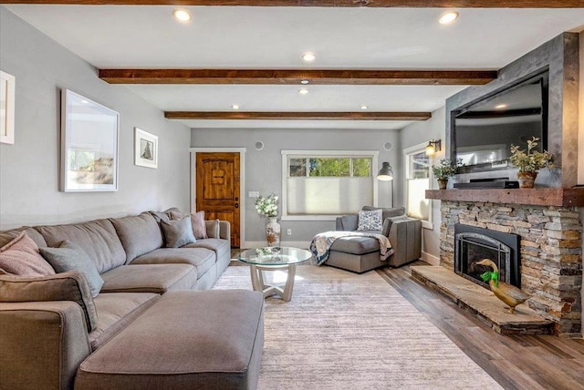 living room with a fireplace, beamed ceiling, and hardwood / wood-style flooring