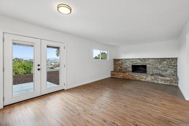 unfurnished living room with a fireplace, french doors, and hardwood / wood-style floors