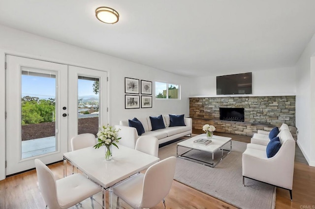 living room featuring french doors, a wealth of natural light, and light hardwood / wood-style flooring