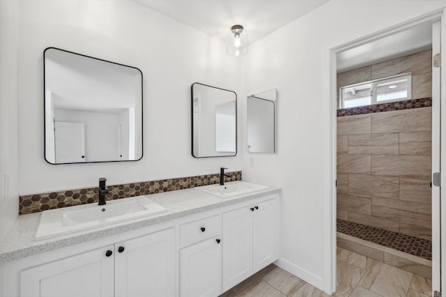 bathroom with a tile shower and vanity