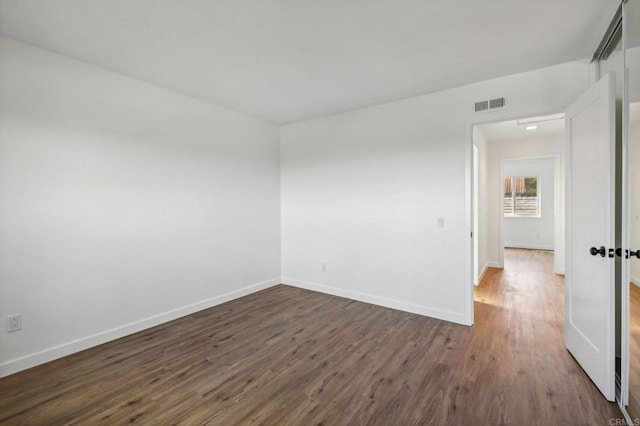 unfurnished room featuring dark wood-type flooring