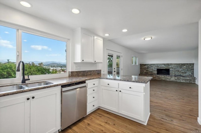 kitchen with dishwasher, white cabinetry, kitchen peninsula, and light hardwood / wood-style flooring