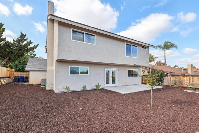 rear view of house with central AC unit, a patio, and french doors