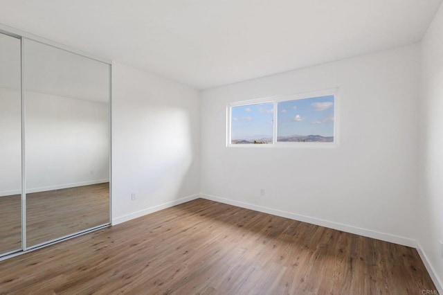 unfurnished bedroom with hardwood / wood-style flooring and a closet