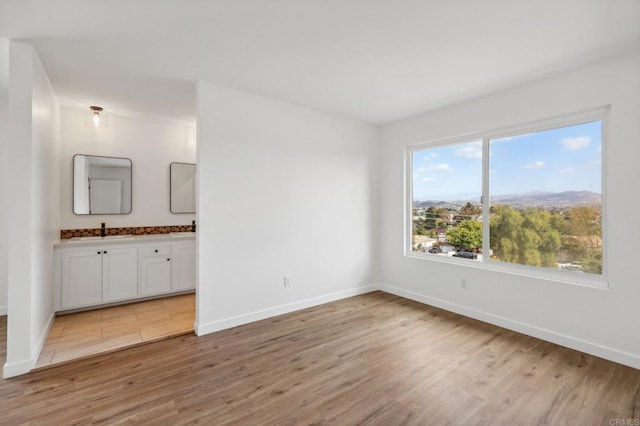 spare room with light hardwood / wood-style flooring and sink