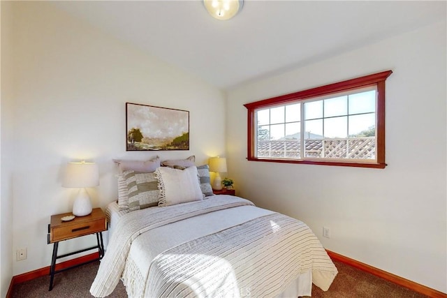 bedroom featuring dark carpet and lofted ceiling