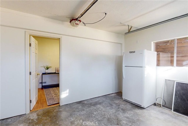 garage with white refrigerator and a garage door opener