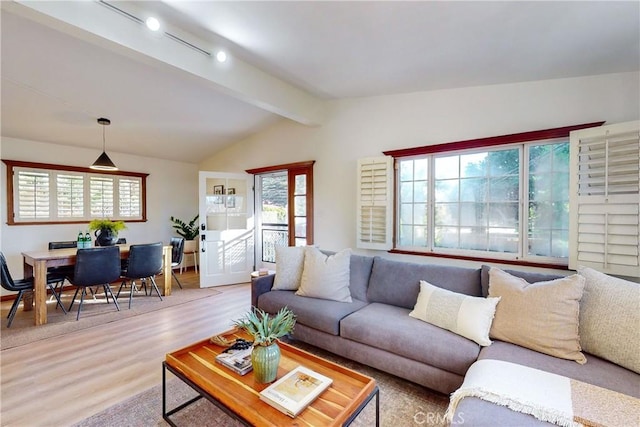 living room with light hardwood / wood-style floors and lofted ceiling with beams