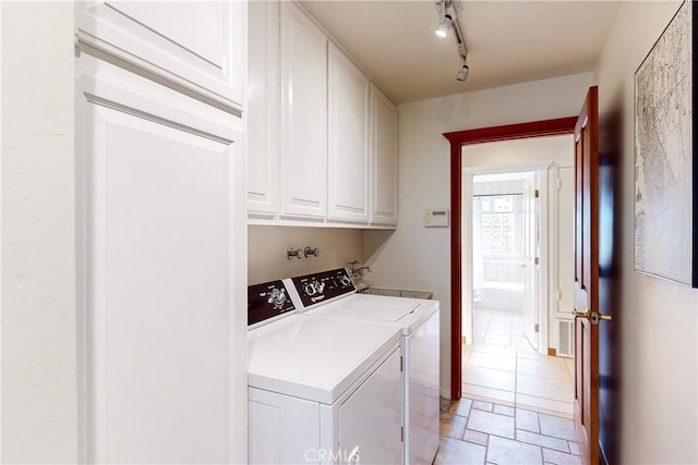 washroom featuring cabinets, independent washer and dryer, and rail lighting