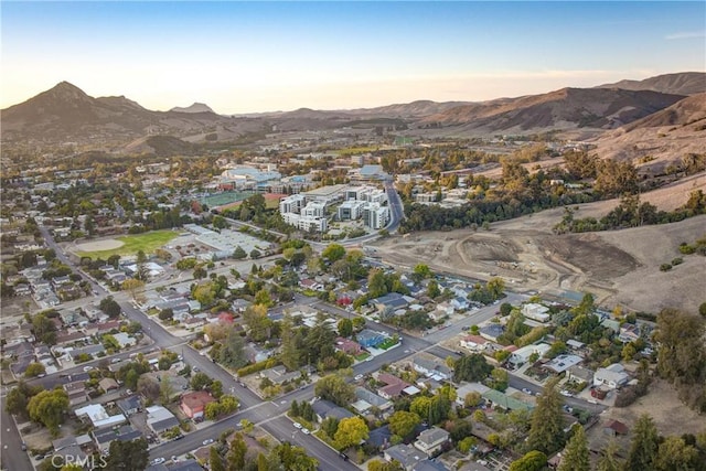 aerial view at dusk featuring a mountain view