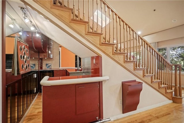 stairway with wood-type flooring and sink