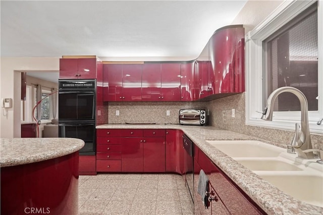 kitchen featuring black double oven, tasteful backsplash, and sink