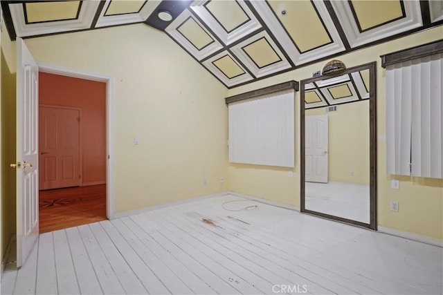 spare room featuring lofted ceiling and light wood-type flooring