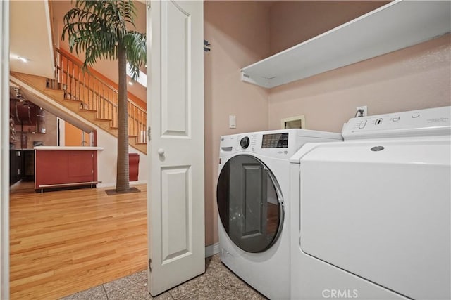 laundry area with light hardwood / wood-style floors and separate washer and dryer