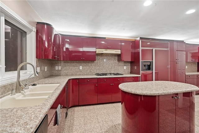 kitchen with tasteful backsplash, sink, paneled refrigerator, and stainless steel gas cooktop