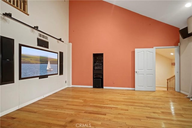 interior space with high vaulted ceiling and light hardwood / wood-style flooring