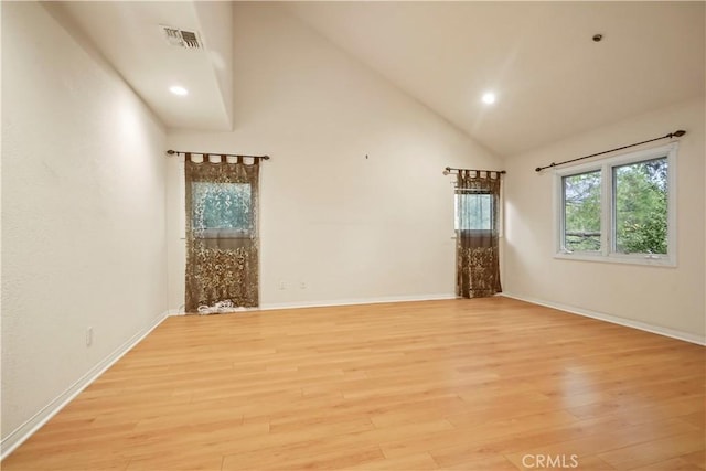 unfurnished room featuring light wood-type flooring and high vaulted ceiling