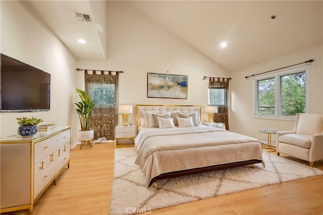 bedroom with light hardwood / wood-style floors and high vaulted ceiling