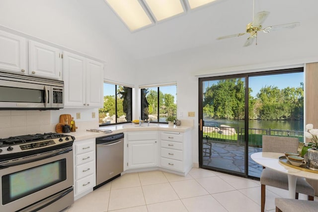 kitchen with white cabinetry, plenty of natural light, a water view, and appliances with stainless steel finishes