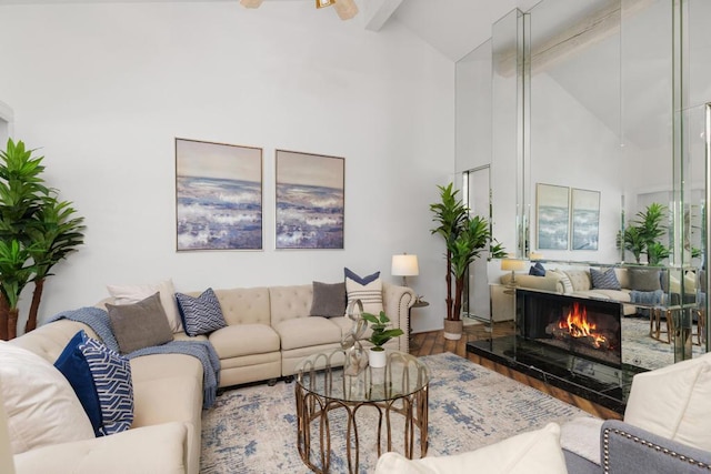 living room with hardwood / wood-style flooring, ceiling fan, beamed ceiling, and high vaulted ceiling