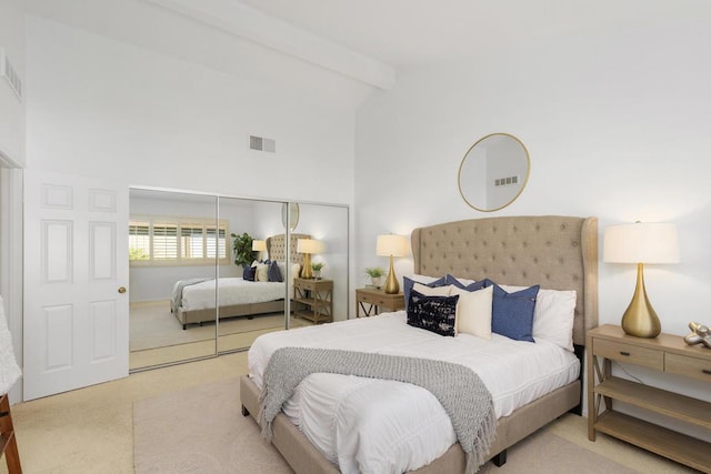 carpeted bedroom with beam ceiling, high vaulted ceiling, and a closet