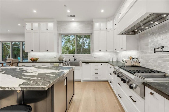 kitchen with white cabinets, a wealth of natural light, and stainless steel gas cooktop