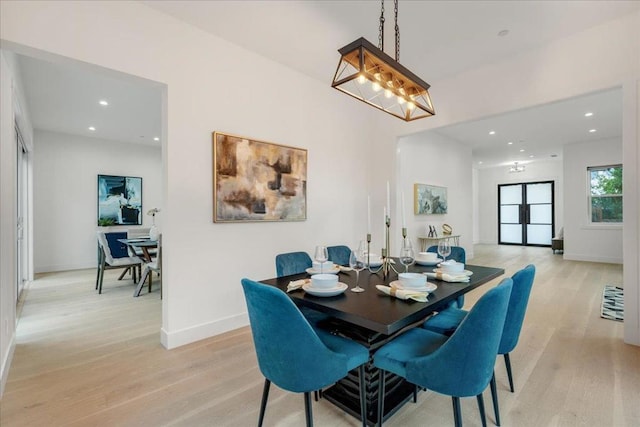 dining space featuring light hardwood / wood-style flooring and an inviting chandelier