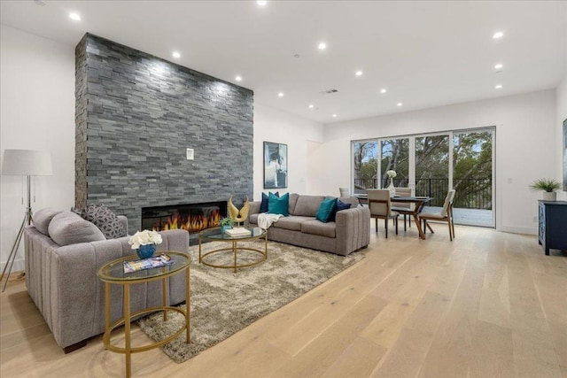 living room with a fireplace and light wood-type flooring