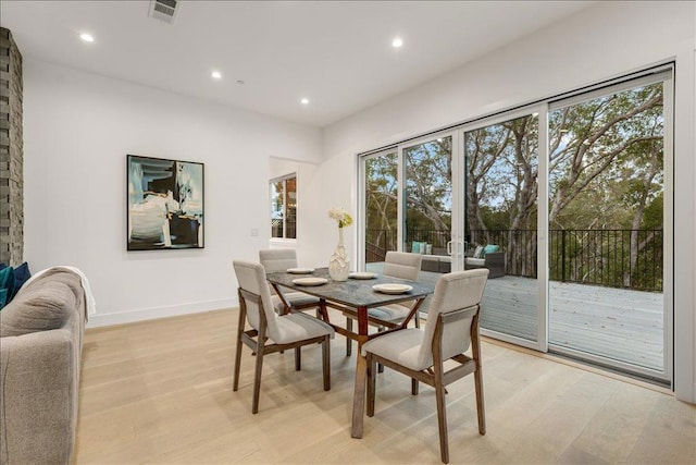 dining area with plenty of natural light and light hardwood / wood-style flooring