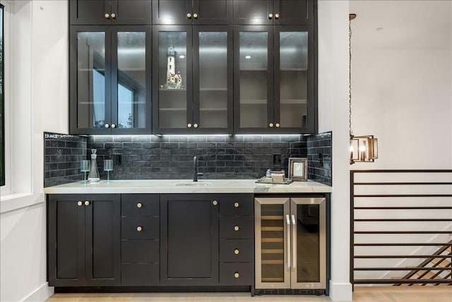 bar with wine cooler, decorative backsplash, sink, and pendant lighting