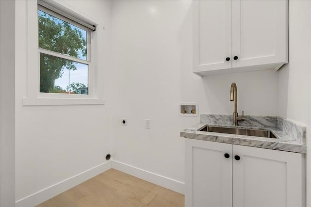 laundry area featuring electric dryer hookup, hookup for a washing machine, sink, and cabinets